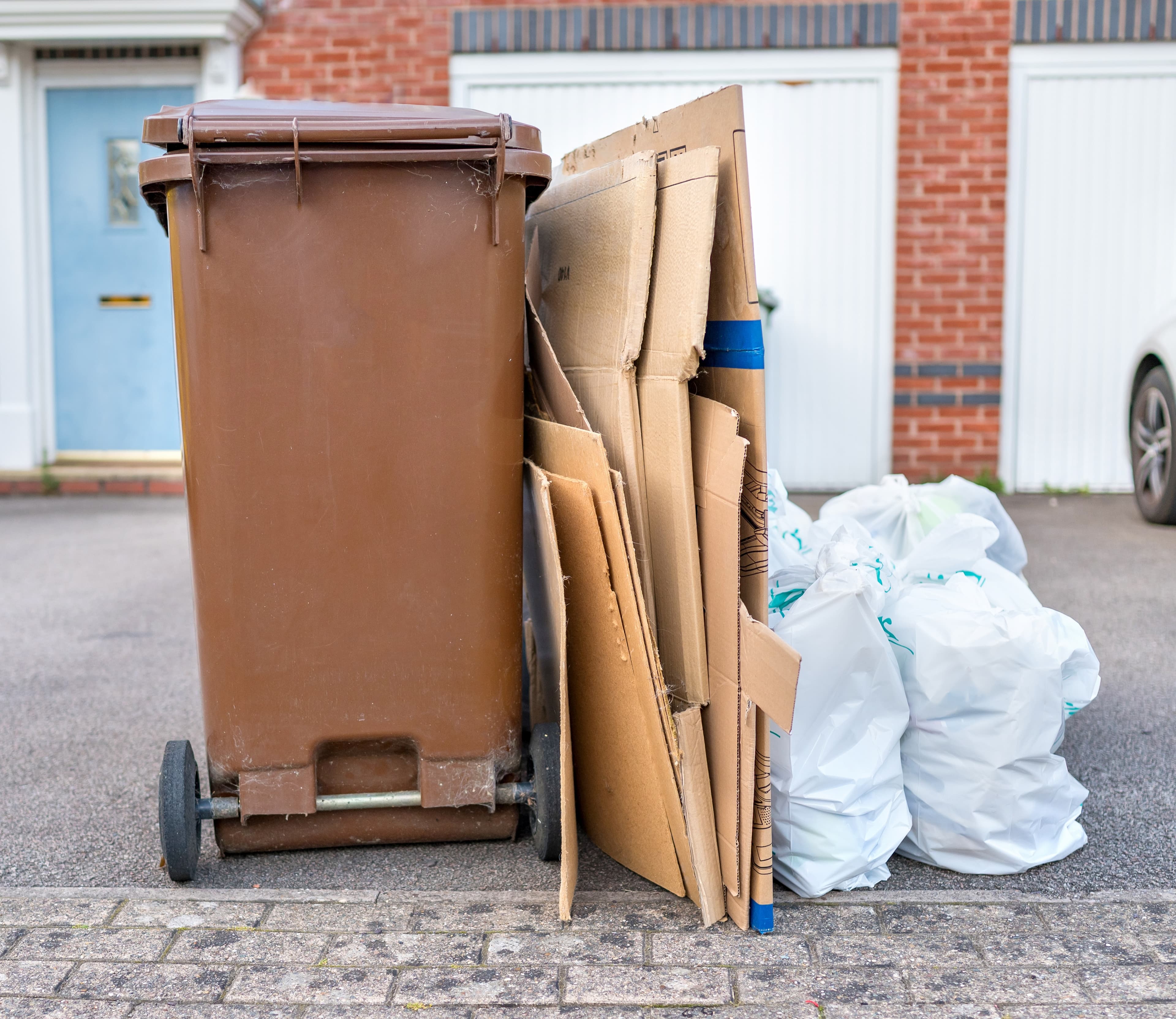 Overflow household waste and cardboard awaiting collection outside residential home